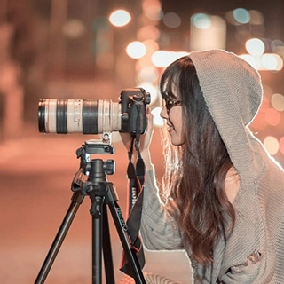 Femme derrière un appareil photo sur trépied
